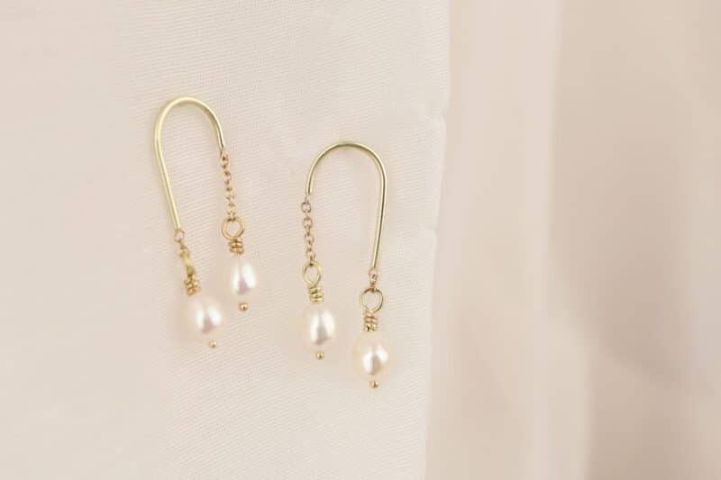 gouden oorhangers in boogjes met parels