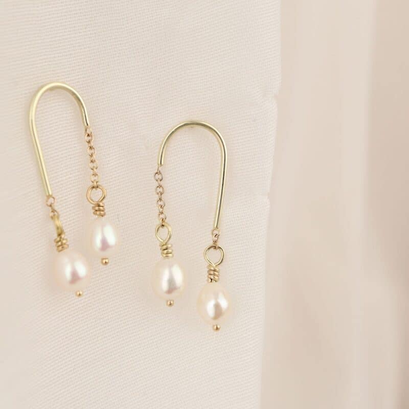 gouden oorhangers in boogjes met parels