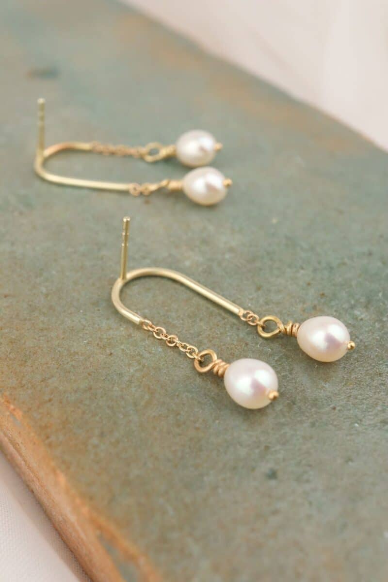 gouden oorhangers in boogjes met parels