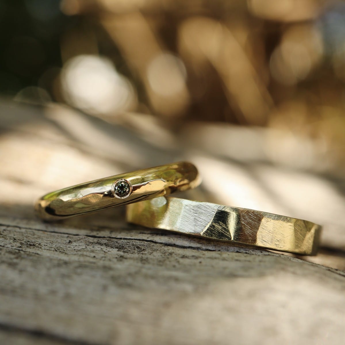 Minimalistische set trouwringen met groene diamant