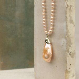 Parelcollier met oranje kleine pareltjes en gouden hanger